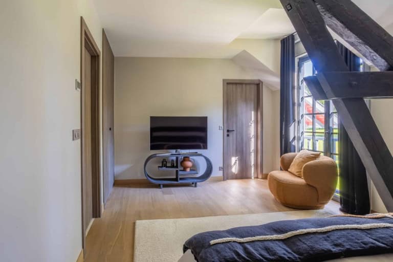 Chambre avec coin télévision et fauteuil en velours