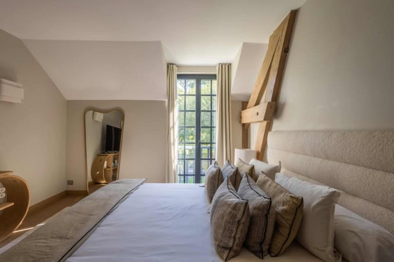 Grand lit garni de coussins dans une chambre d'une maison d'exception