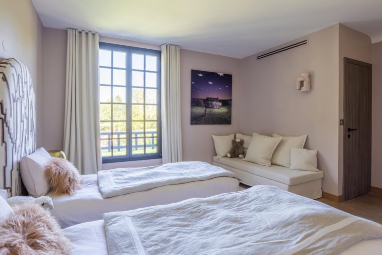 Chambre lumineuse avec lits jumeaux et coin salon
