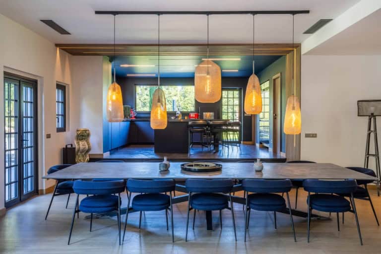 Grande table de salle à manger sous une rangée de suspensions