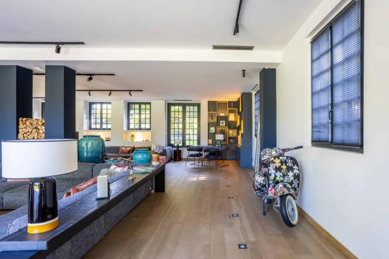 Pièce de vie aux poteaux sombres et parquet clair dans une propriété près de Deauville