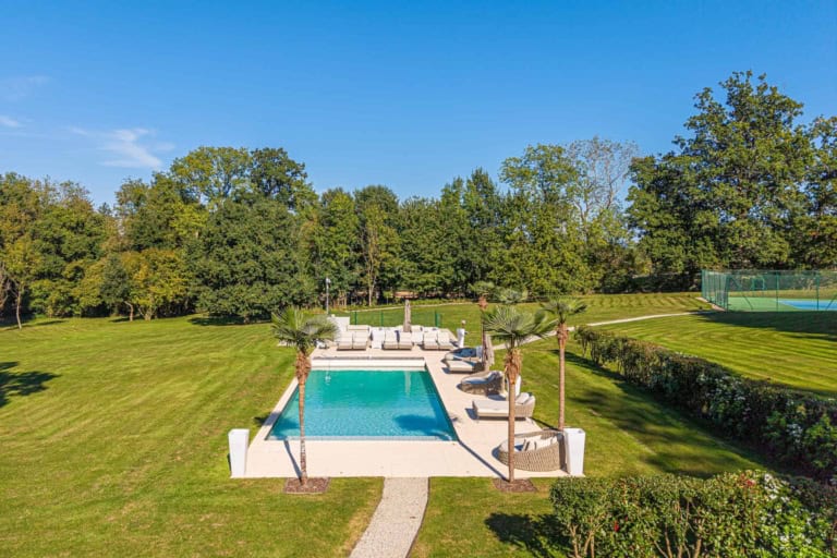 Piscine bordée de pelouse dans le jardin d'une propriété d'exception près de Deauville