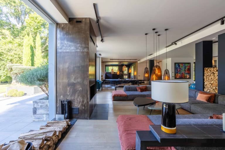 Salon avec cheminée ouvert sur le jardin dans une maison d'exception