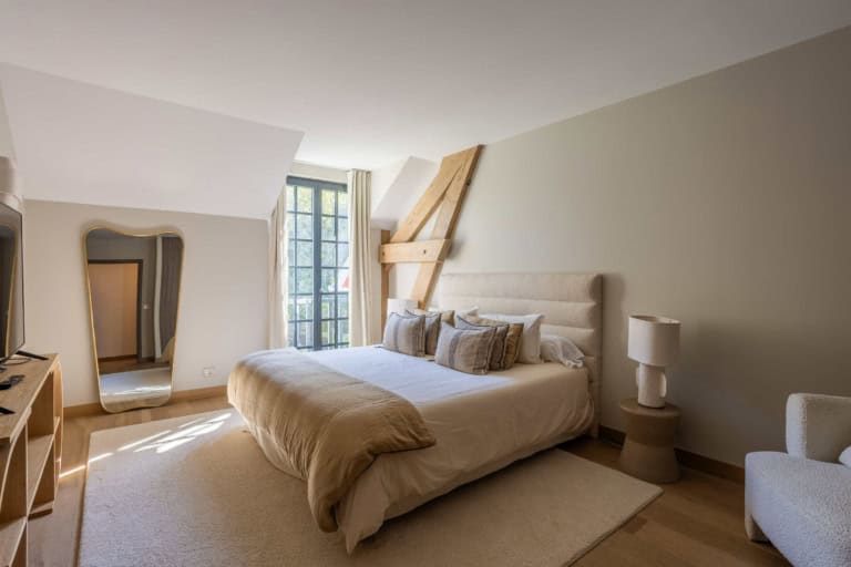 Chambre lumineuse sous les poutres d'une demeure normande