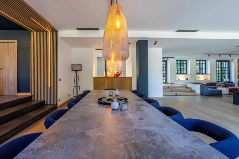 Salle à manger design avec table en pierre et chaises bleues