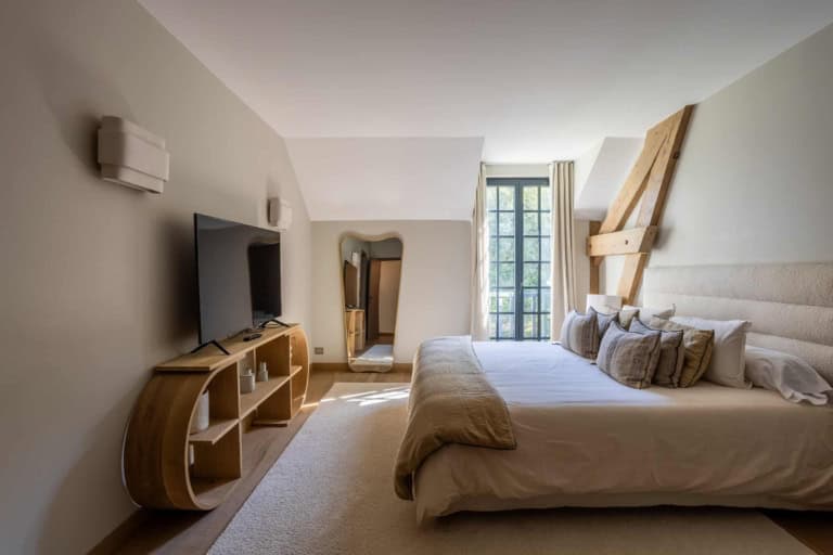Chambre avec poutres apparentes et grand lit dans une propriété près de Deauville