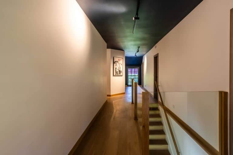 Couloir lumineux et escalier vers l'étage d'une propriété de prestige