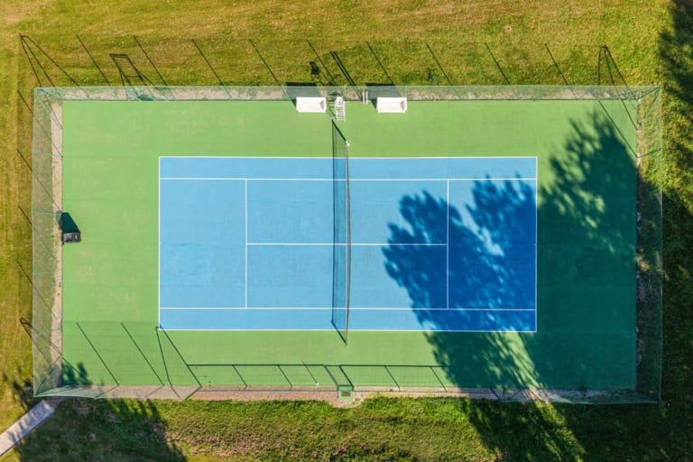 Court de tennis vu du ciel dans le parc d'une propriété près de Deauville