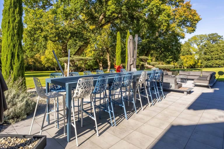 Grande table de repas sur la terrasse extérieure d'une propriété de prestige